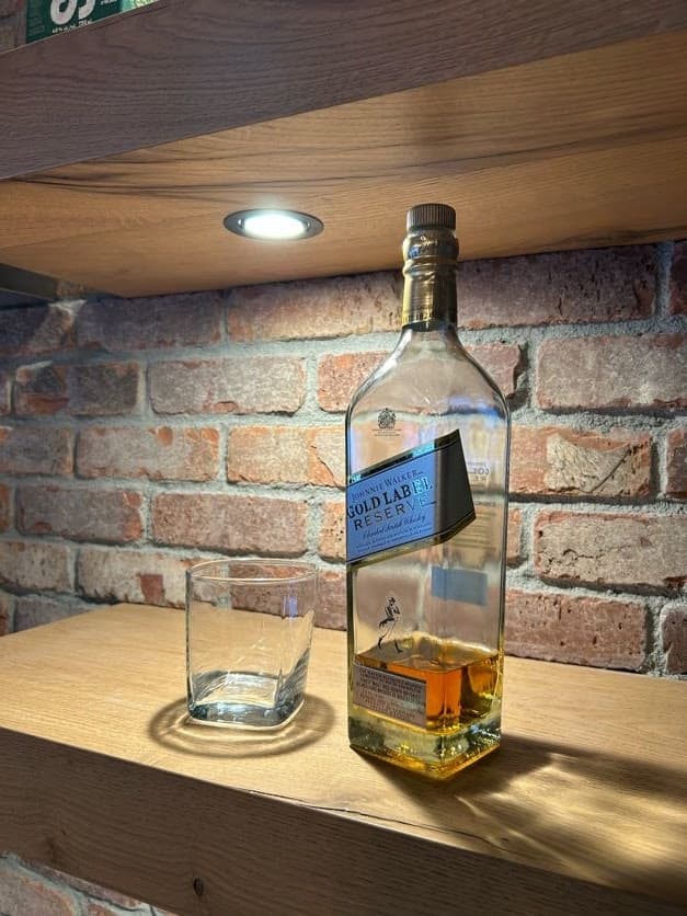 Exposed brick veneer feature wall in a bar setting showing warm red brick and tight mortar joints